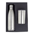 A silver stainless steel water bottle and a tumbler with a clear lid are placed in a black foam-lined box. The bottle is tall and sleek, while the tumbler is cylindrical and shorter.