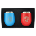 A gift box containing two stainless steel wine tumblers, one blue and one red, each engraved with the phrase Wine Not? The tumblers have a metallic rim and are set against a black foam background.