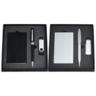 Two gift sets displayed side by side in black boxes. Each set contains a pen, a USB flash drive, and a card holder. The left set is black, while the right is silver. Items are neatly arranged in foam inserts.
