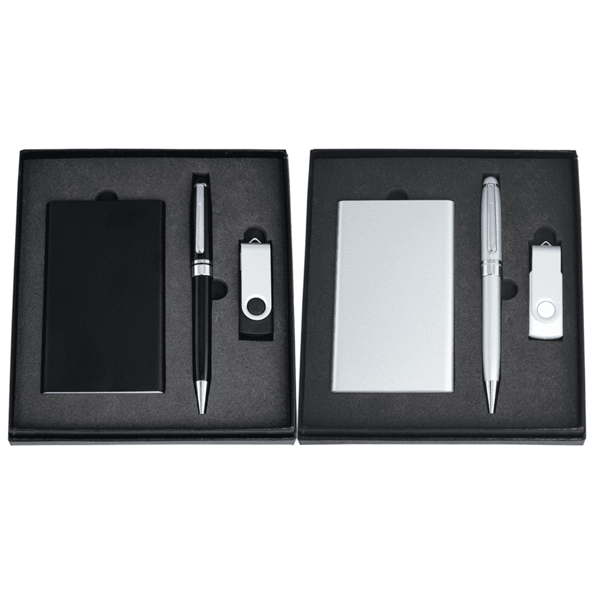 Two gift sets displayed side by side in black boxes. Each set contains a pen, a USB flash drive, and a card holder. The left set is black, while the right is silver. Items are neatly arranged in foam inserts.