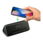 A hand holding a smartphone above a triangular black wireless charging station, with a green lightning symbol indicating charging. The phone screen shows a partially charged battery icon.