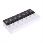 A weekly pill organizer with seven compartments labeled with days of the week and AM and PM on each lid, arranged in two rows. The lids are black, and the base is white.