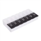 A white weekly pill organizer with seven black compartments labeled with days of the week: SAT, FRI, THU, WED, TUE, MON, SUN. All compartments are marked pm. The lids are open, showing empty compartments.