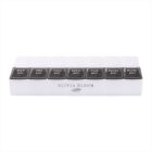 A weekly pill organizer with seven compartments labeled for each day: SAT, FRI, THU, WED, TUE, MON, SUN. Each compartment features am and pm markings. The organizer has the brand name Olivia Bloom printed below.