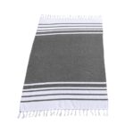 Gray towel with white fringe on both ends. It features two white stripes near each end, with multiple thinner stripes just above and below these main stripes. The towel is laid flat, displaying its rectangular shape.
