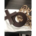 A dark wooden Venus symbol rests on a white cloth. Surrounding the symbol is a coiled rope with wooden beads, all placed on a dark wooden surface.