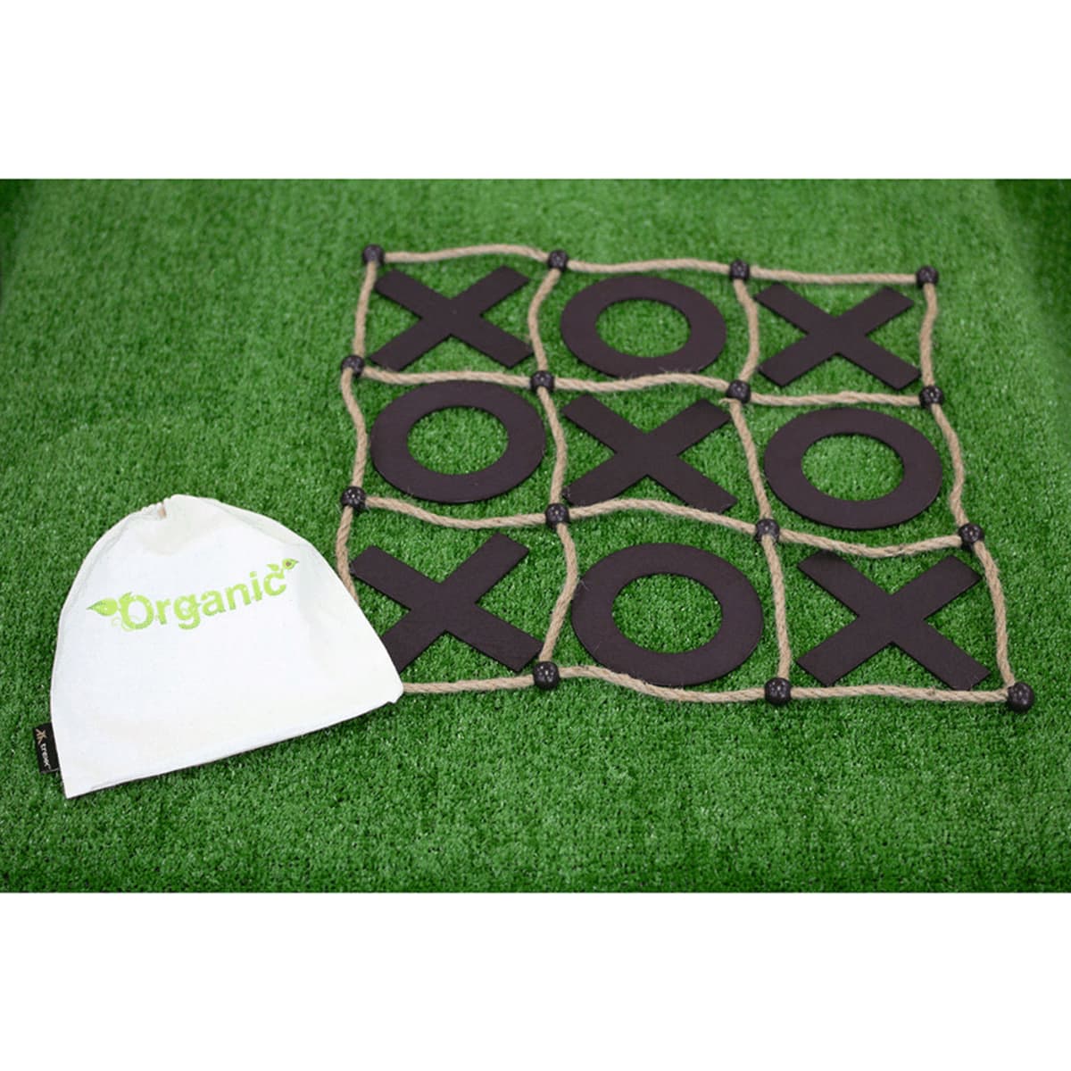 A tic-tac-toe game with black Xs and Os is laid out on a green surface. A white pouch labeled Organic is placed next to the game board.