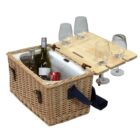 Wicker picnic basket with a handle, featuring an open lid holding four empty wine glasses. The basket contains two wine bottles, a soda can, and an ice pack inside.