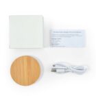 Wireless charger with cable, instruction manual, and white box on a white background.
