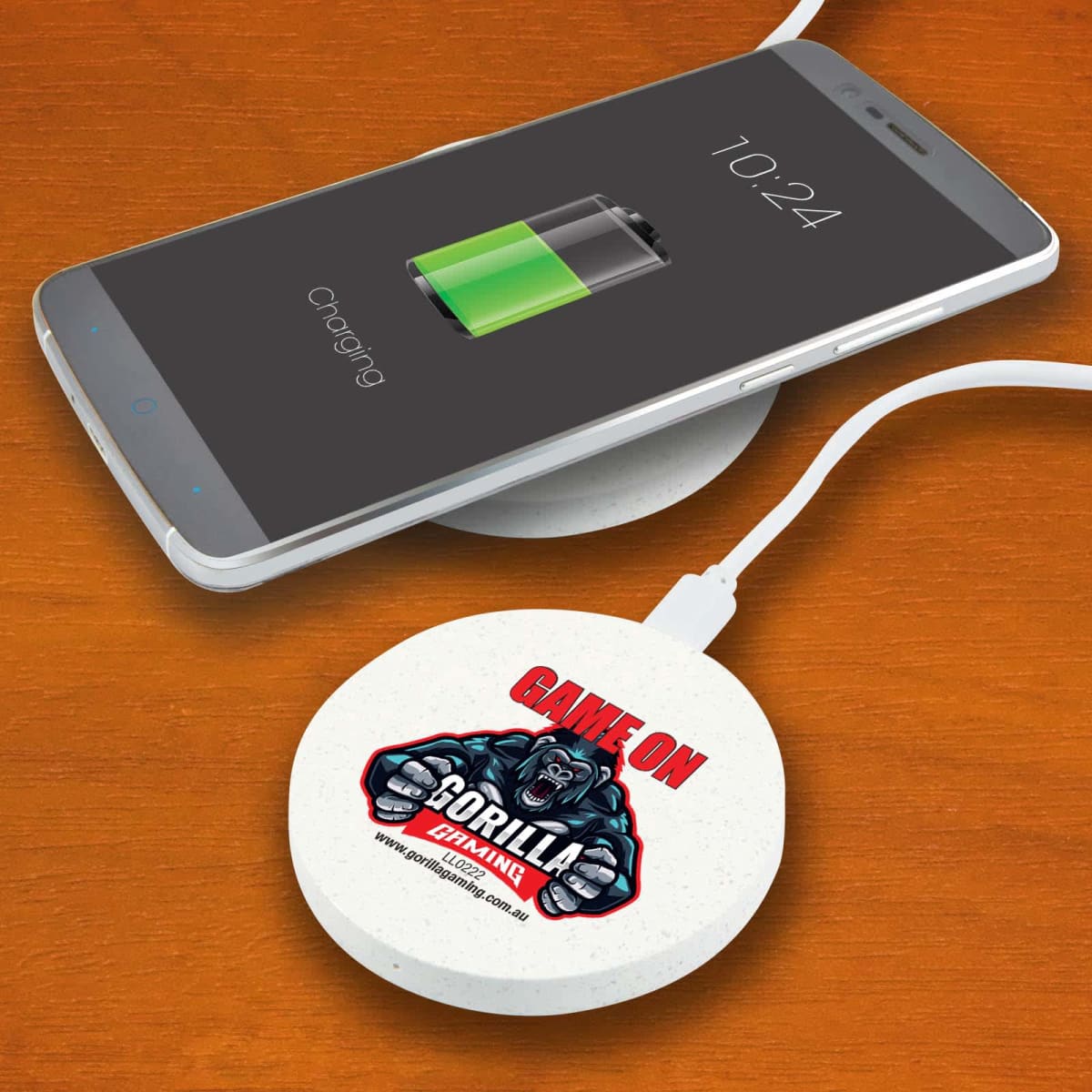 Smartphone charging on a wireless pad with Gorilla logo on a wooden surface.