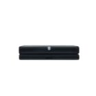 Black closed gaming console viewed from the side.