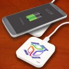 Smartphone charging wirelessly on a pad that says Guardian Collection.
