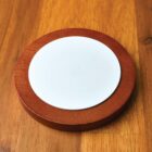 A white plate on a wooden table.