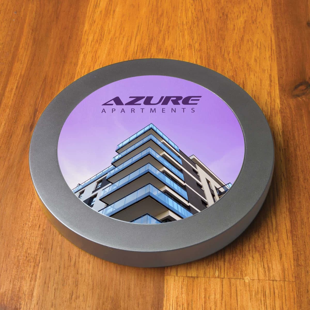 Round coaster with Azure Apartments and an image of a modern building.