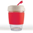 Clear glass tumbler with a red silicone sleeve, cream lid, and red straw.