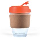 Reusable glass cup with orange lid and cork sleeve.