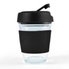 Clear glass cup with a black silicone sleeve and a black lid with a spout.