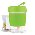 Green reusable cup with a flip lid next to a bag of colorful candies.