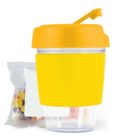 Yellow snack cup with a yellow lid, accompanied by a packet of colorful candies.