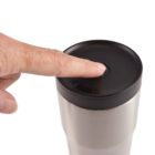 Finger pressing button on a stainless steel travel mug lid.