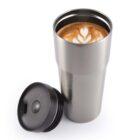 A stainless steel tumbler with latte art and a black lid beside it.