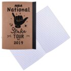 Brown notebook titled NBA National Shake Tour 2019 next to an open lined notebook.