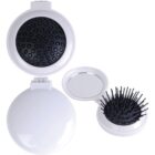 Round white compact with mirror and pop-out hairbrush.
