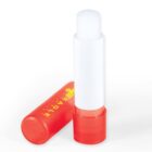 Red and white glue stick, with one cap off and standing upright.