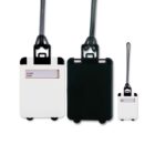 Three luggage tags: one white front with name slot, one solid black, and a smaller white one. Each has a black strap.