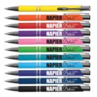 A set of 12 colorful pens with NAPIER Deluxe printed on them, each a different color including yellow and red.