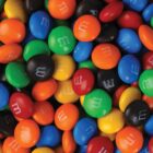 A colorful assortment of M&Ms candies scattered, featuring red, blue, green, orange, yellow, and black pieces.