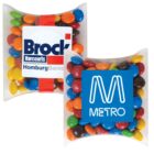 Two pillow-shaped packs of colorful candies with Brock and Metro logos on them.
