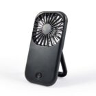 Black portable handheld fan with a circular vent and a foldable stand, positioned upright against a white background.