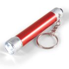 Red metallic flashlight keychain with a silver chain and lit LED bulb at the end.
