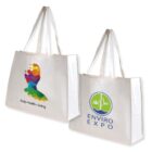 Two white tote bags are displayed. The left bag features a colorful silhouette and the text Body • Health • Living. The right bag shows a green and blue logo with leaves and water, and is labeled ENVIRO EXPO. Both have white handles.