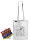 A white tote bag featuring an outline drawing of a pirate sitting on treasure with a parrot, a shovel, and waves. Next to it is a box of brightly colored crayons.