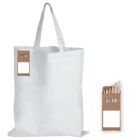 A plain white tote bag with two handles is shown. Attached to it is a small cardboard box containing assorted colored pencils, visible through an open window. The box is positioned to the right of the bag in a separate, smaller image.