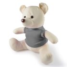 A beige teddy bear wearing a gray T-shirt is seated upright with its arms outstretched and legs spread apart. It has a round brown nose and dark eyes. The bear is positioned against a plain white background.