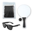 A set of items on a white background: a black mesh net packaged in a transparent bag, a white paddle with a black handle, a black ball, and a pair of black sunglasses.