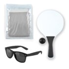 A set of items including a transparent bag with a folded gray towel or cloth inside, a black-handled white paddle, a small black ball, and a pair of black sunglasses with tinted lenses.