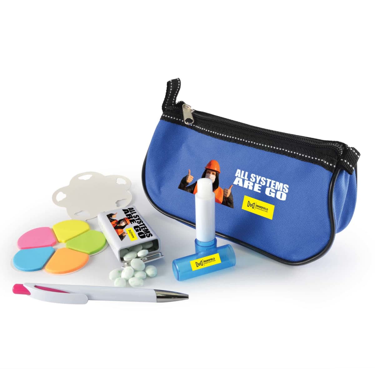 A blue zippered pouch with a graphic and text All Systems Are Go contains stationery items: sticky notes in various colors, a pen, a glue stick, a white notepad, and small tablets in a clear container.