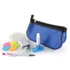 A blue zippered pouch surrounded by various items: a pen, colorful sticky notes shaped like flowers, a white tube with a blue base, a small open tin with round mints, and a white object clipped onto the pouch.