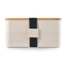 A minimalist, beige bento box with a wooden lid is secured by a black strap. It consists of two stacked compartments, designed for carrying meals.