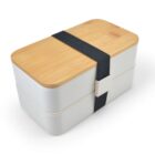 A rectangular, two-tiered bento box with a light wooden lid and a white base, secured by a thick black elastic band. The lid features a natural wood grain pattern.
