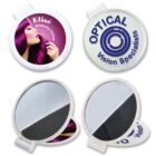 Four round pocket mirrors: one with a purple-haired woman and Elisé Amazing Colour text, and one with OPTICAL Vision Specialists logo. Both mirrors are open, showing reflective surfaces.