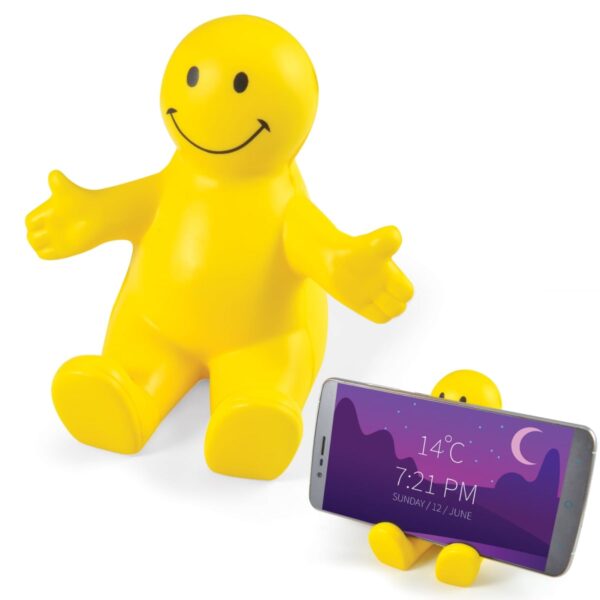 A yellow smiling plastic figure with outstretched arms sits beside a similar smaller figure holding a smartphone. The phone displays a weather app indicating 14°C and the time 7:21 PM on Sunday, 12 June.