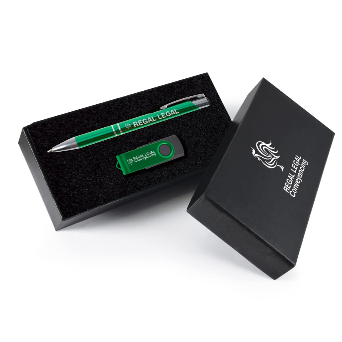 A black gift box with silver text containing a green pen and a green USB flash drive, both branded with Regal Legal. The box is partially open, resting on a white background.