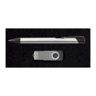 A silver and black ballpoint pen placed next to a small silver and black USB flash drive on a black background.