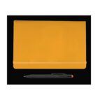 A closed yellow notebook with an elastic band lies on a black background. Below the notebook is a black pen with an orange tip.