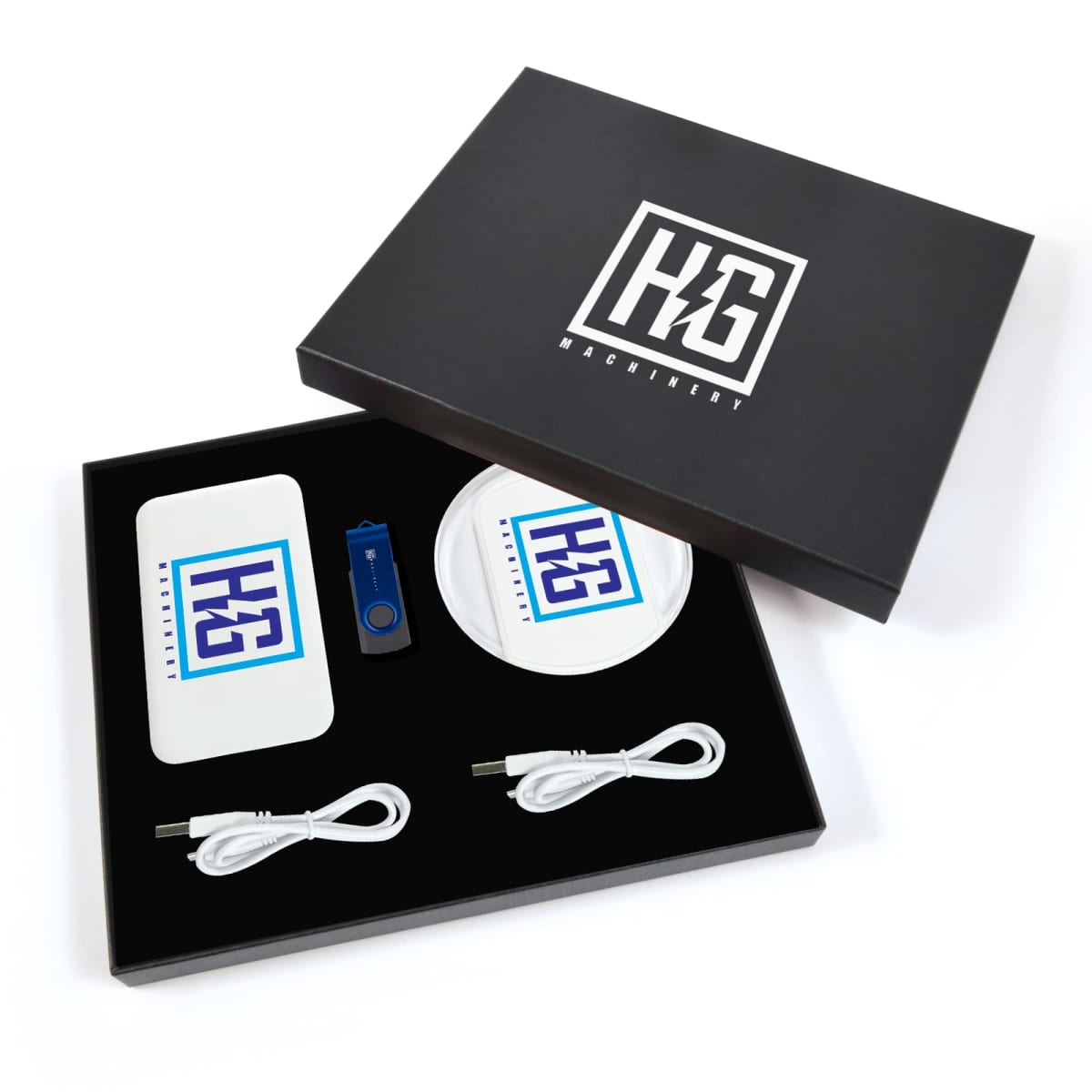 A branded gift set in a black box, containing two wireless chargers with a logo, a blue USB drive, and two white charging cables, all neatly arranged on a black background. The box lid displays the same logo.